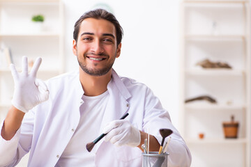 Young male archaeologist studying ancient african stonemask