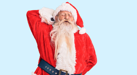 Old senior man with grey hair and long beard wearing traditional santa claus costume suffering of neck ache injury, touching neck with hand, muscular pain