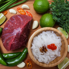 making pho bo vietnamese soup. serving of soup in a white plate. view from above. Fresh natural ingredients.