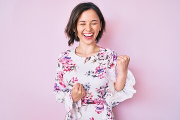 Young beautiful woman wearing casual clothes celebrating surprised and amazed for success with arms raised and eyes closed