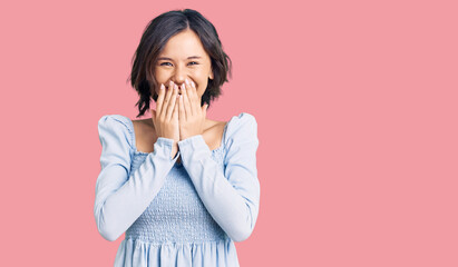 Young beautiful girl wearing casual clothes laughing and embarrassed giggle covering mouth with hands, gossip and scandal concept