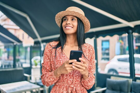 Young african american tourist woman on vacation smiling happy using smartphone at the city.