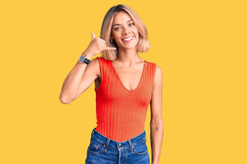 Beautiful caucasian woman wearing casual clothes smiling doing phone gesture with hand and fingers like talking on the telephone. communicating concepts.