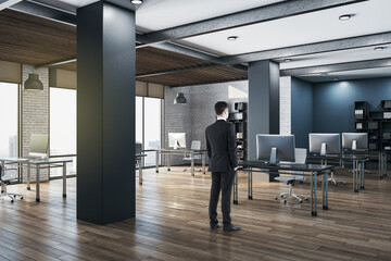 Businessman standing in panoramic open space modern office