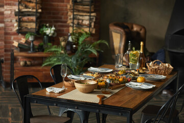 Homey background image of wooden table served for Thanksgiving dinner with friends and family, copy...