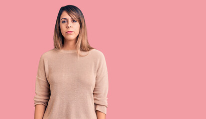 Young beautiful woman wearing casual sweater with serious expression on face. simple and natural looking at the camera.