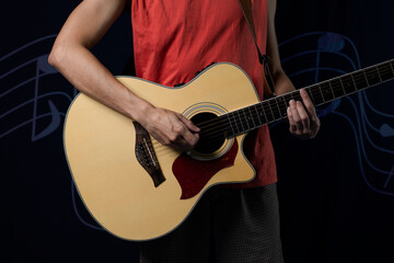 Obraz na płótnie Canvas Musician with an acoustic guitar in the dark.