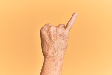 Senior caucasian hand over yellow isolated background showing little finger as pinky promise...