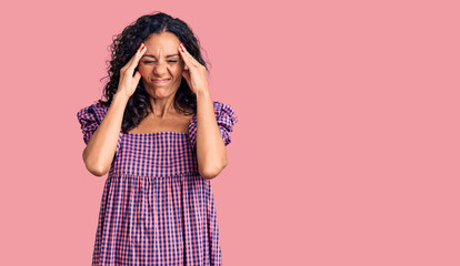 Middle age beautiful woman wearing casual dress suffering from headache desperate and stressed because pain and migraine. hands on head.