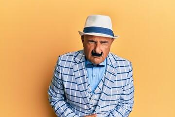 Mature middle east man with mustache wearing vintage and elegant fashion style with hand on stomach because indigestion, painful illness feeling unwell. ache concept.