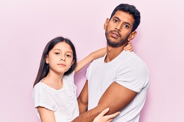 Young father and daughter wearing casual clothes relaxed with serious expression on face. simple and natural looking at the camera.