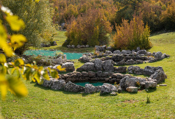 Ancient roman Rajcica wells located in the countryside of Croatia, 40 km away from Split. Round stone formations hidden in the forest overgrown with beautiful green grass. Pasture for local cows