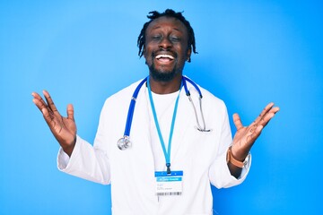 Young african american man with braids wearing doctor stethoscope and id pass celebrating mad and crazy for success with arms raised and closed eyes screaming excited. winner concept