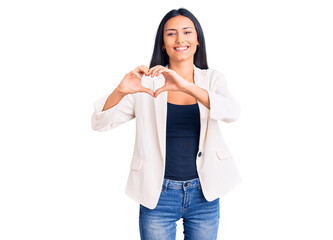 Young beautiful latin girl wearing business clothes smiling in love showing heart symbol and shape with hands. romantic concept.