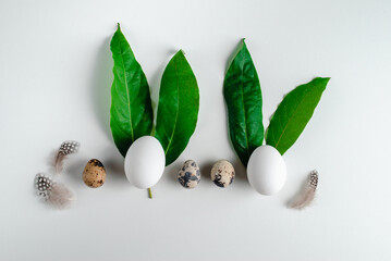 Happy Easter greeting card. Easter eggs with green leaves in the form of bunnies.