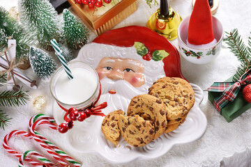 glass of milk and cookies on festive table for Santa Claus