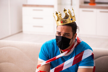 Young man with crown on head at home