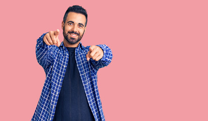 Young hispanic man wearing casual clothes pointing to you and the camera with fingers, smiling positive and cheerful