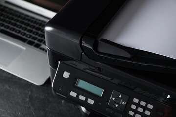 Closeup view of new modern printer with control panel on black table
