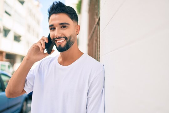 Young arab man with serious expression talking on the smartphone at the city.