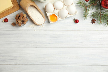 Flat lay composition with ingredients for traditional Christmas cake on white wooden table. Space for text