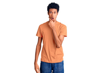 Fototapeta premium Young african american man wearing casual clothes looking fascinated with disbelief, surprise and amazed expression with hands on chin