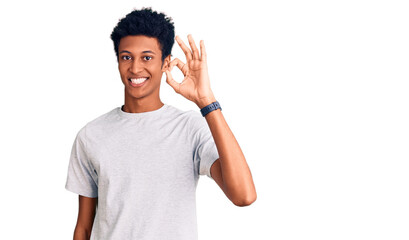 Young african american man wearing casual clothes smiling positive doing ok sign with hand and fingers. successful expression.