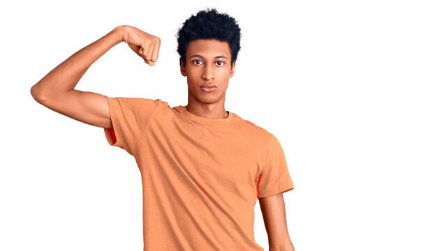 Young african american man wearing casual clothes strong person showing arm muscle, confident and proud of power