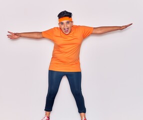 Adorable hispanic kid wearing sportswear smiling happy. Jumping with smile on face over isolated white background