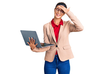 Young beautiful woman holding laptop stressed and frustrated with hand on head, surprised and angry face