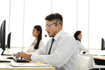 Group of happy call center smiling business operator customer support team phone services agen working and talking with headset on desktop computer at call center