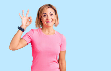 Young blonde woman wearing sportswear smiling positive doing ok sign with hand and fingers. successful expression.