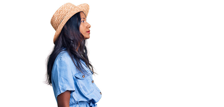 Young indian girl wearing summer hat looking to side, relax profile pose with natural face and confident smile.