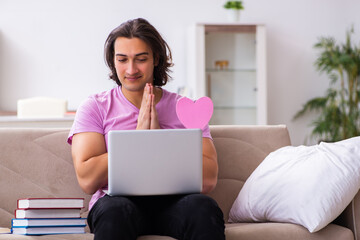 Male student in love preparing for exams at home