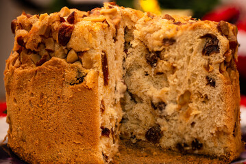 Fruit panettone topped with chestnuts on a plate decorated for Christmas