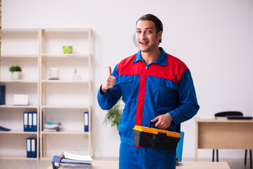 Young male contractor repairing furniture in the office