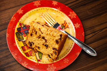Panettone slice of fruit topped with chestnuts on a table decorated for Christmas