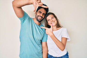 Beautiful young couple of boyfriend and girlfriend together smiling making frame with hands and fingers with happy face. creativity and photography concept.