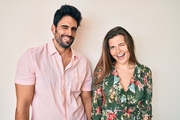 Beautiful young couple of boyfriend and girlfriend together winking looking at the camera with sexy...