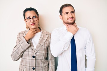 Beautiful couple wearing business clothes touching painful neck, sore throat for flu, clod and infection