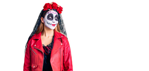 Woman wearing day of the dead costume over background smiling looking to the side and staring away thinking.