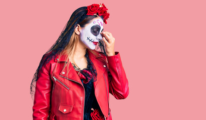 Obraz premium Woman wearing day of the dead costume over background tired rubbing nose and eyes feeling fatigue and headache. stress and frustration concept.