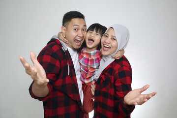 Happy Asian muslim family, father mother and baby girl daughter looking at camera and smiling with greeting gesture