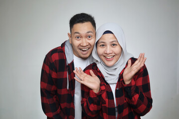Happy Asian muslim couple, husband and wife looking at camera and posing for photograph, happy cheerful expression