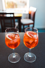 wine glasses with orange spritz cocktails on kitchen countertop