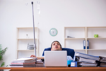Young male employee suffering at workplace