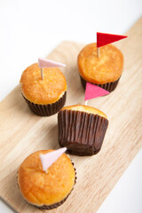Obraz na płótnie Canvas muffins with small flag on cutting board