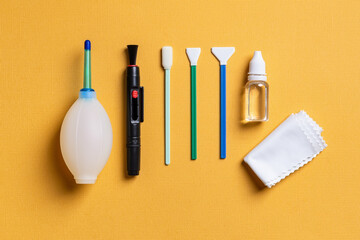 Air blower, lens pen, three different swabs, liquid sensor cleaner and microfiber on a textured...