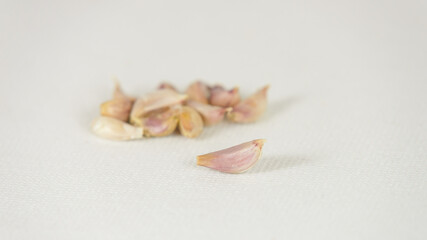 Fototapeta na wymiar Fresh garlic cloves on white canvas background with copy space. select focus