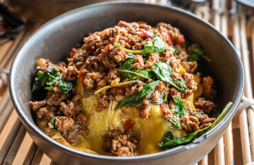 Close-up of Thai stir fried basil (Phat kaphrao) serving on the table. Phat kaphrao consists of meat such as pork, chicken, beef etc. stir fried with Thai holy basil and garlic.
